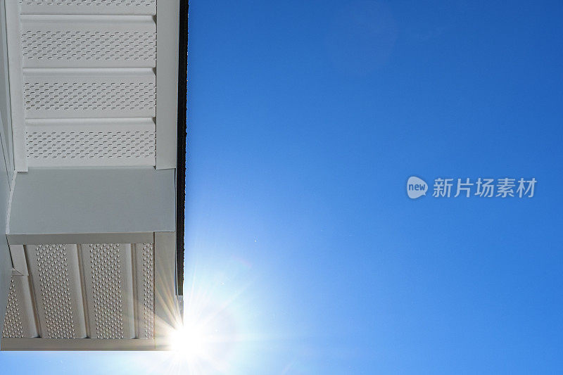 Looking up at newly installed fascia and perforated soffit – sun flare